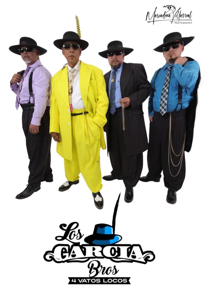 Four men in band stand with big hats and suits.